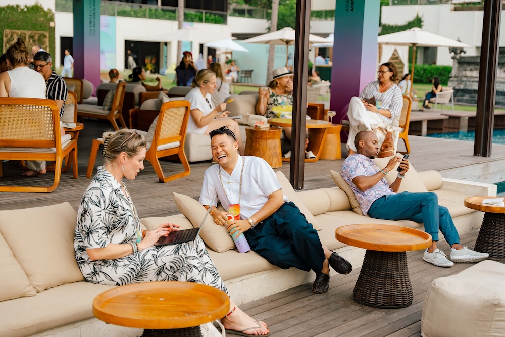 Delegates networking by the pool on loungers